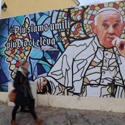 Una mujer camina frente a un fresco que representa al papa Francisco cerca de la catedral de Ajaccio, en Ajaccio, Córcega, cinco días antes de la visita del Papa a la isla mediterránea francesa. | Foto:PASCAL POCHARD-CASABIANCA / AFP