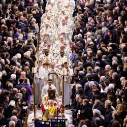 Miembros del clero y portadores de estandartes caminan hacia el nuevo altar principal durante su consagración, como parte de la primera misa para el público, en la catedral de Notre-Dame de París. | Foto:Ludovic Marin / AFP