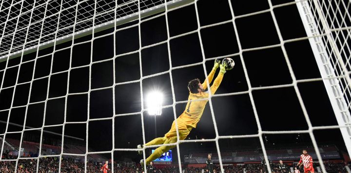 El arquero brasileño del Liverpool, Alisson Becker, se lanza para atajar la pelota durante el partido de fútbol de la fase de liga de la UEFA Champions League entre el Girona FC y el Liverpool FC en el estadio Montilivi en Girona.