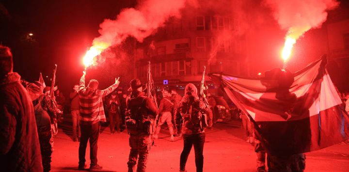 Las fuerzas rebeldes disparan al aire mientras celebran en la ciudad de Homs, en el centro de Siria, tras haber entrado en la tercera ciudad de Siria durante la noche. Hayat Tahrir al-Sham (HTS) y las facciones antigubernamentales aliadas han lanzado una ofensiva relámpago, arrasando con zonas del país que estaban bajo el control del gobierno, incluidas las principales ciudades de Alepo, Hama, Homs y la capital, Damasco.