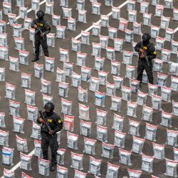 Miembros del cuerpo antidrogas hacen guardia junto a los paquetes de presunta droga en la Dirección Nacional de Control de Drogas (DNCD) luego de una incautación de 9,5 toneladas de presunta cocaína en Santo Domingo, República Dominicana. | Foto:FRANCESCO SPOTORNO / AFP