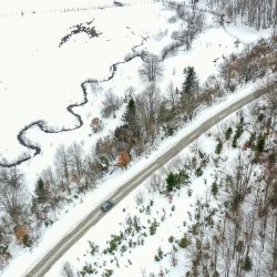 Vista aérea tomada con un dron de un automóvil circulando en una autopista en el Parque Nacional Mavrovo después de una nevada, en Mavrovo, en Macedonia del Norte. | Foto:Xinhua/Tomislav Georgiev