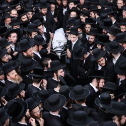 Los dolientes ultraortodoxos llevan el cuerpo de Yehoshua Aharon, de 12 años, quien fue asesinado por un hombre armado en un ataque a un autobús israelí cerca de Belén en la Cisjordania ocupada el día anterior, durante su funeral en Jerusalén. | Foto:HMAD GHARABLI / AFP