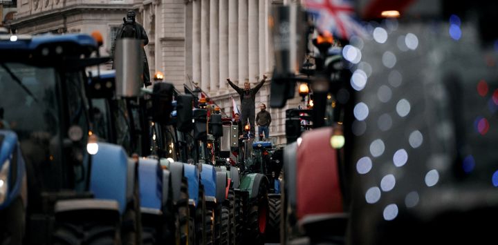 Un agricultor se encuentra sobre el techo de un tractor estacionado a lo largo de Whitehall durante una manifestación para detener “la muerte de la agricultura británica”, en protesta contra los cambios en las reglas del impuesto a la herencia para la propiedad de la tierra de los agricultores, en el centro de Londres.