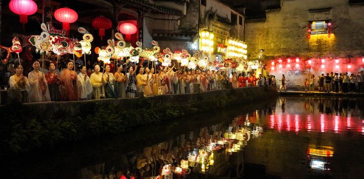 Vista aérea tomada con un dron de personas sosteniendo linternas festivas mientras desfilan, en la aldea Hongcun del distrito de Yixian, en el este de China.