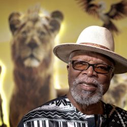 El actor, director y dramaturgo sudafricano John Kani sonríe durante una sesión fotográfica antes del estreno en Sudáfrica de "Mufasa, el Rey León" de Disney en Johannesburgo. John Kani, que ya había prestado su voz al sabio Rafiki en la nueva versión de 2019 de El Rey León, repetirá el papel de Rafiki en la película precuela de 2024 "Mufasa: El Rey León". | Foto:MARCO LONGARI / AFP