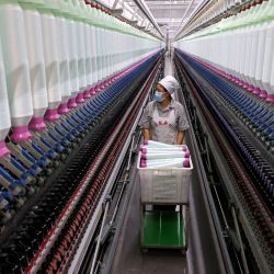 Esta foto muestra a un trabajador que controla una línea de producción de hilos de alta gama en una fábrica en Zaozhuang, provincia de Shandong, en el este de China. | Foto:AFP