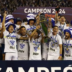 Los jugadores de Vélez Sarsfield celebran con el trofeo tras ganar el Torneo de la Liga Profesional de Fútbol Argentino 2024 'Cesar Luis Menotti' durante el partido de fútbol entre Vélez Sarsfield y Huracán en el estadio José Amalfitani en Buenos Aires. | Foto:ALEJANDRO PAGNI / AFP