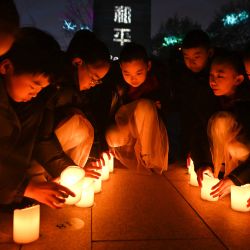 Niños colocan velas mientras asisten a una vigilia con velas en el Salón Conmemorativo de las Víctimas de la Masacre de Nanjing por los Invasores Japoneses, en Nanjing, capital de la provincia de Jiangsu, en el este de China. | Foto:Xinhua/Ji Chunpeng