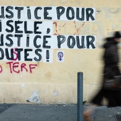 Un peatón pasa junto a un mural en el que se lee "Justicia para Gisele, justicia para todos" cerca del juzgado de Aviñón, donde se lleva a cabo el juicio por violación de Mazan en Aviñón, sur de Francia. | Foto:CLEMENT MAHOUDEAU / AFP