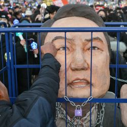 Un manifestante que pide la destitución del presidente de Corea del Sur, Yoon Suk Yeol, golpea una efigie suya tras el resultado de la segunda votación para imponer la ley marcial en el exterior de la Asamblea Nacional en Seúl. | Foto:Anthony Wallace / AFP