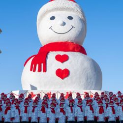 Alumnos realizan una presentación frente a un muñeco de nieve gigante, en Harbin, en la provincia de Heilongjiang, en el noreste de China. | Foto:Xinhua/Zhang Tao