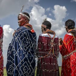 Mujeres masai vestidas con atuendos tradicionales observan las competencias desde el campo en los Juegos Olímpicos masai 2024 en Kimana. Los Juegos Olímpicos masai son un evento bienal que celebra la cultura masai y promueve la conservación de la vida silvestre al reemplazar la caza tradicional con competencias atléticas inspiradas en las habilidades de los guerreros masai. | Foto:LUIS TATO / AFP