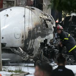 Un bombero inspecciona los restos de un avión Challenger 300 que se estrelló al aterrizar en la localidad de San Fernando, provincia de Buenos Aires. El piloto y el copiloto murieron luego de que el avión privado se estrellara durante el aterrizaje y se incendiara cerca del aeropuerto de San Fernando. No se reportaron otros heridos. | Foto:JUAN MABROMATA / AFP