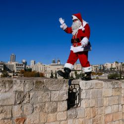 El palestino Issa Kassissieh, vestido de Papá Noel, posa para una foto en la Puerta de Jaffa, en la Ciudad Vieja de Jerusalén, antes de la próximas vacaciones de Navidad. | Foto:MENAHEM KAHANA / AFP