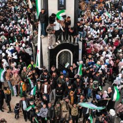 Esta vista aérea muestra a personas celebrando el derrocamiento del presidente sirio Bashar al-Assad, alrededor de la Nueva Torre del Reloj a lo largo de la calle Quwatli en el centro de Homs. | Foto:Aaref Watad / AFP
