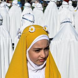 Las niñas musulmanas iraquíes, que tradicionalmente comienzan a usar el hijab (un velo que se usa en público) a la edad obligatoria de nueve años, participan en una ceremonia organizada en un estadio de Basora. | Foto:Hussein Faleh / AFP