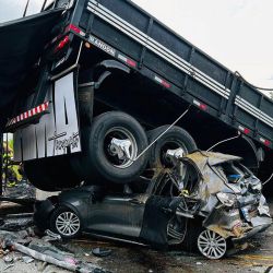 La imagen difundida por el Departamento de Bomberos de Minas Gerais muestra un camión sobre un automóvil en el lugar de un accidente en Teofilo Otoni, estado de Minas Gerais, Brasil. | Foto:Handout / Departamento de Bomberos de Minas Gerais / AFP