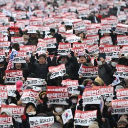 Varias personas sostienen carteles que dicen "Oposición al impeachment, arresten a Lee Jae-myung" mientras participan en una manifestación en apoyo del presidente de Corea del Sur destituido, Yoon Suk Yeol, en el centro de Seúl. | Foto:Jung Yeon-je / AFP