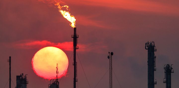 El sol se pone detrás de las llamaradas de gas en llamas en el complejo de refinería de petróleo de Dora en Bagdad, Irak.