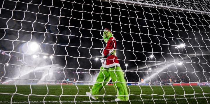 Una persona vestida como el Grinch pasa por delante del arco en el descanso durante el partido de fútbol de la Premier League inglesa entre Crystal Palace y Arsenal en Selhurst Park en el sur de Londres.