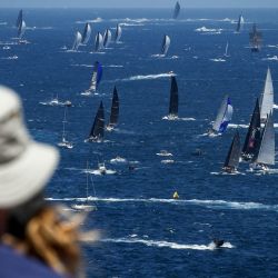 Los espectadores en North Head observan la competición de yates durante el inicio de la carrera anual de yates de Sídney en el puerto de Sídney. | Foto:DAVID GRAY / AFP