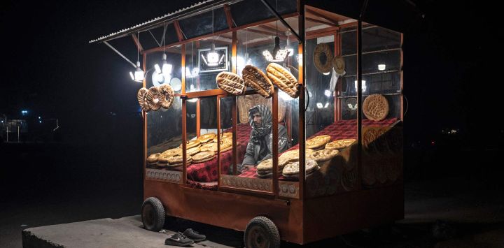 Esta fotografía muestra a un vendedor afgano que vende panes planos tradicionales, conocidos localmente como naan, mientras espera a los clientes en una carretera en Kabul.