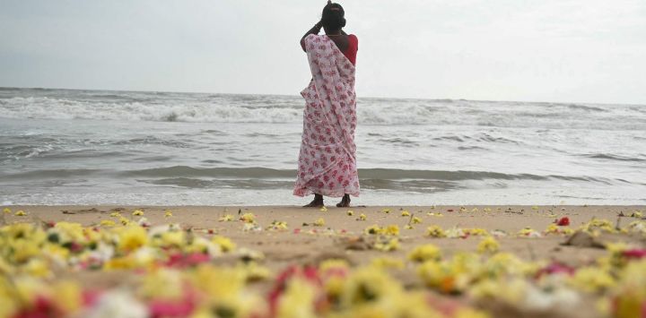 Flores esparcidas en la playa después de que las mujeres realizaran rituales durante una ceremonia celebrada en honor a las víctimas del tsunami del Océano Índico de 2004, en la playa de Pattinapakkam en Chennai, India.