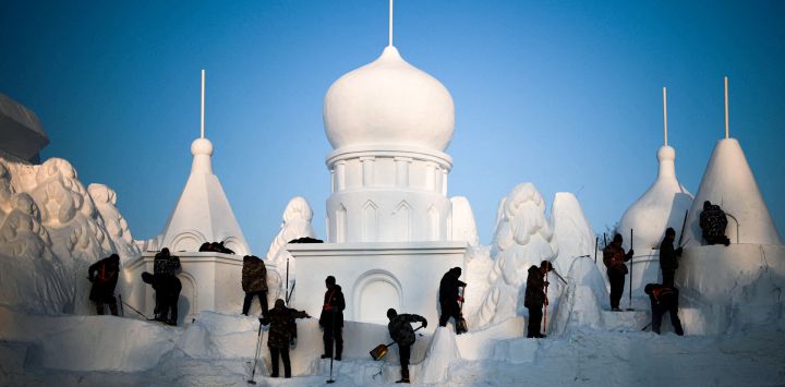 Hombres trabajan en esculturas de hielo durante la 37ª Exposición Internacional de Arte de Esculturas de Nieve de la Isla del Sol en Harbin, en la provincia nororiental china de Heilongjiang.