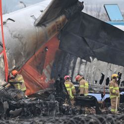 Los bomberos y los equipos de rescate trabajan en el lugar donde un avión Boeing 737-800 de Jeju Air se estrelló y estalló en llamas en el Aeropuerto Internacional de Muan en Muan, a unos 288 kilómetros al suroeste de Seúl. | Foto:Jung Yeon-je / AFP