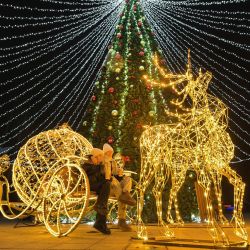 Los visitantes disfrutan de las decoraciones navideñas en el centro de Mariupol, bajo control ruso. | Foto:STRINGER / AFP)