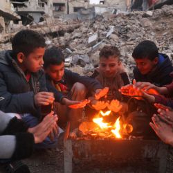 Niños se calientan junto al fuego en el campamento de desplazados palestinos de Bureij, en medio de la continua guerra entre Israel y el grupo militante Hamás. Desde que comenzó la guerra entre Israel y Hamás en octubre del año pasado, los 2,4 millones de habitantes de Gaza han sufrido una grave escasez de electricidad, agua potable, alimentos y servicios médicos. | Foto:Eyad Baba / AFP