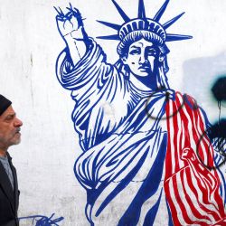 Un hombre pasa junto a un grafiti que representa a la Estatua de la Libertad con el brazo que porta la antorcha roto, dibujado en las paredes de la antigua sede de la embajada de Estados Unidos que fue asaltada y ocupada por estudiantes iraníes en noviembre de 1979 y en el que 53 personas fueron tomadas como rehenes, en Teherán. | Foto:ATTA KENARE / AFP