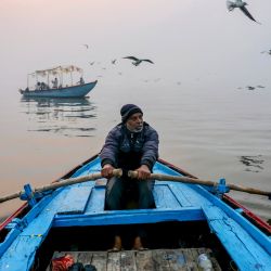 Un hombre rema en su bote a través del río Ganges en una fría mañana de invierno en Varanasi, India. | Foto:NIHARIKA KULKARNI / AFP
