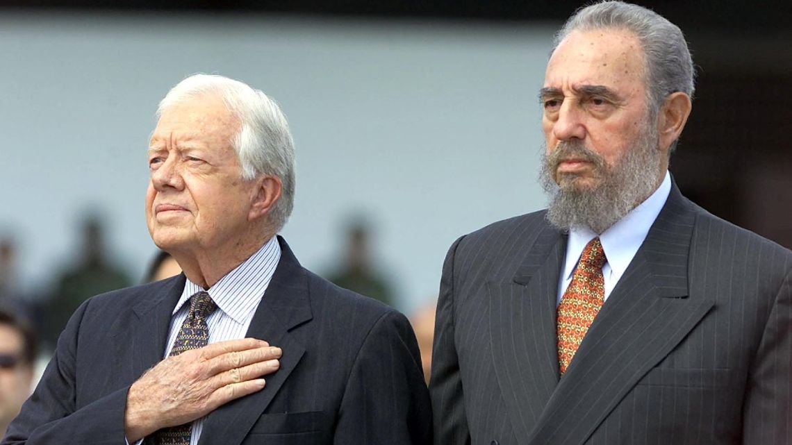 Former US president Jimmy Carter and former Cuban president Fidel Castro listen to the US National Anthem after Carter's arrival at Jose Marti airport in Havana on May 12, 2002. 