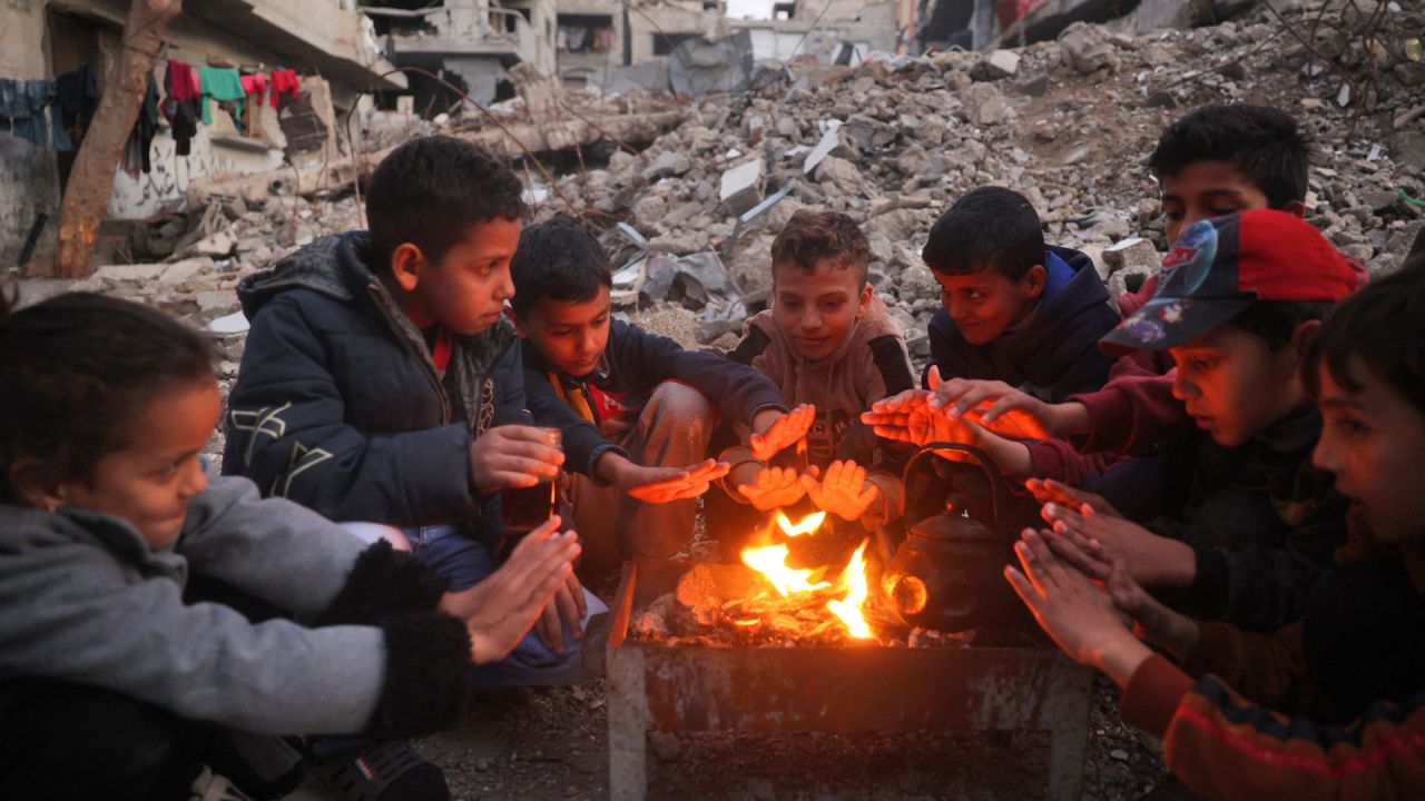 Niños se calientan junto al fuego en el campamento de desplazados palestinos de Bureij, en medio de la continua guerra entre Israel y el grupo militante Hamás. Desde que comenzó la guerra entre Israel y Hamás en octubre del año pasado, los 2,4 millones de habitantes de Gaza han sufrido una grave escasez de electricidad, agua potable, alimentos y servicios médicos. | Foto:Eyad Baba / AFP