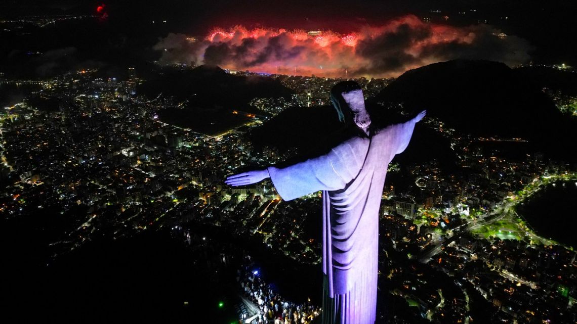 This aerial view shows the Christ The Redeemer statue as fireworks explode all over the city during New Year celebrations in Rio de Janeiro early on January 1, 2025. 