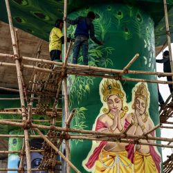 Los trabajadores pintan un mural de deidades hindúes en un pilar, antes del festival Maha Kumbh Mela en Prayagraj, India. | Foto:NIHARIKA KULKARNI / AFP