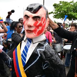 Un manifestante sostiene una efigie del presidente ecuatoriano Daniel Noboa durante una manifestación contra la desaparición de cuatro menores que desaparecieron durante un operativo militar, frente al palacio de justicia en Guayaquil, Ecuador, durante la audiencia de acusación contra 16 militares presuntamente involucrados en la desaparición. | Foto:Marcos Pin / AFP