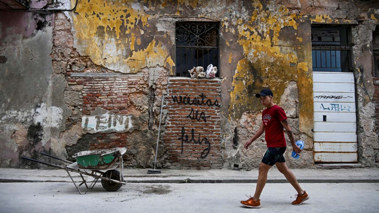 Un hombre pasa junto a un grafiti que dice "Tienes que ser feliz" del artista cubano Mr. Sad en La Habana. Hace más de un año, un grafiti simple y contundente que dice "Tienes que ser feliz" comenzó a aparecer en las desgastadas paredes de La Habana. El mensaje aparentemente inocente se ha convertido en un eco de reflexión para muchos y en una inspiración para los jóvenes creadores cubanos. | Foto:YAMIL LAGE / AFP