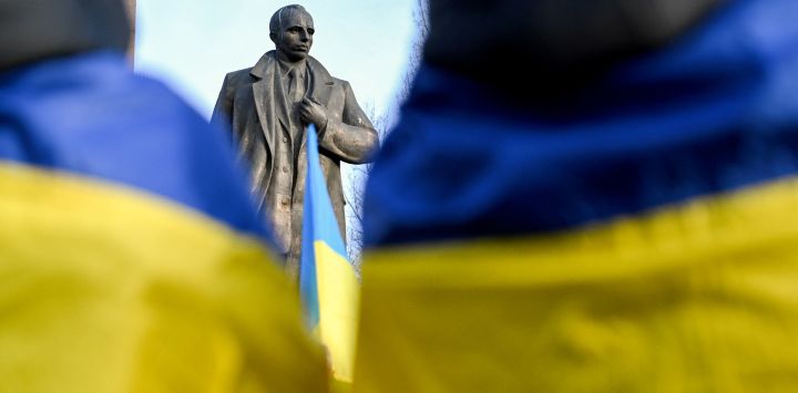 Esta fotografía muestra una estatua que representa al líder de extrema derecha ucraniano y líder de la Organización de Nacionalistas Ucranianos (OUN), Stepan Bandera (1909-1959), mientras la gente asiste a una ceremonia para conmemorar el 116 aniversario de su nacimiento, en la ciudad de Lviv, en el oeste de Ucrania, en medio de la invasión rusa de Ucrania.