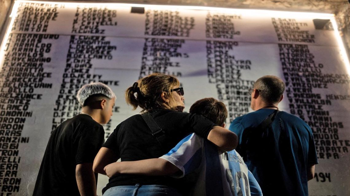 Relatives of the victims mourn during the 20th anniversary of the República Cromañón disco fire, in which 194 young people were killed and hundreds more injured in Buenos Aires on December 30, 2024. The names of the victims are still painted on the exterior walls of the wrecked nightclub. 