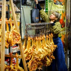 Una mujer cierra su tienda de carne seca y pescado en Hong Kong. | Foto:Mladen Antonov / AFP