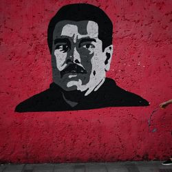 Una mujer pasa junto a un mural que representa al presidente venezolano Nicolás Maduro en Caracas. El 10 de enero, Maduro prestará juramento para un tercer mandato de seis años, después de rechazar las acusaciones de que robó las elecciones de julio al candidato opositor ahora exiliado Edmundo González Urrutia, quien afirma haber ganado de manera aplastante. | Foto:Federico Parra / AFP