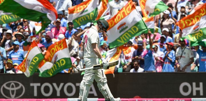 El australiano Travis Head camina hacia el vestuario mientras los fanáticos indios celebran durante el segundo día del quinto partido de prueba entre Australia y la India en el Sydney Cricket Ground.