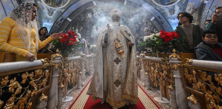 Un sacerdote dirige las celebraciones de la Nochebuena ortodoxa en la Iglesia Ortodoxa Copta Arcángel Miguel en El Cairo, Egipto.