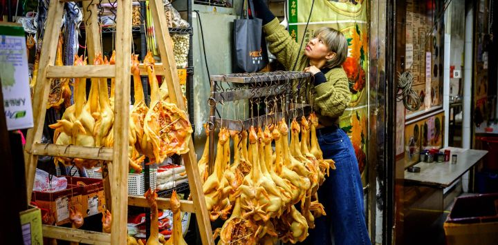 Una mujer cierra su tienda de carne seca y pescado en Hong Kong.