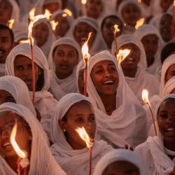 Los fieles sostienen velas y firman himnos religiosos mientras se reúnen en vísperas de las celebraciones navideñas ortodoxas etíopes en la iglesia Bole Medhanialem en Addis Abeba. | Foto:Amanuel Sileshi / AFP