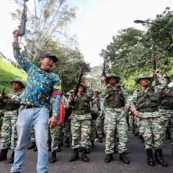 Miembros de la Milicia Bolivariana y partidarios del gobierno levantan fusiles de asalto mientras participan en una manifestación durante una marcha de juramentación de las fuerzas combatientes en Caracas, el presidente de Venezuela, Nicolás Maduro, prestará juramento para un tercer mandato de seis años, después de desestimar las acusaciones de que robó las elecciones de julio al ahora exiliado candidato de la oposición, Edmundo González Urrutia, quien afirma haber ganado de manera aplastante. | Foto:PEDRO MATTEY / AFP