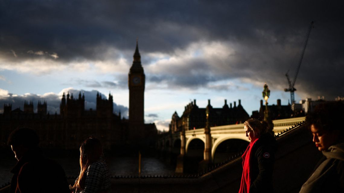 Pedestrians walk along the Southbank of the River Thames, with the Elizabeth Tower, commonly known by the name of the clock's bell "Big Ben", at the Palace of Westminster, home to the Houses of Parliament, in the background, in central London, at sunset, on January 6, 2025. 